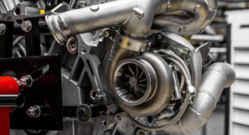 A close-up view of a high-performance turbocharger and custom boost piping on an engine.