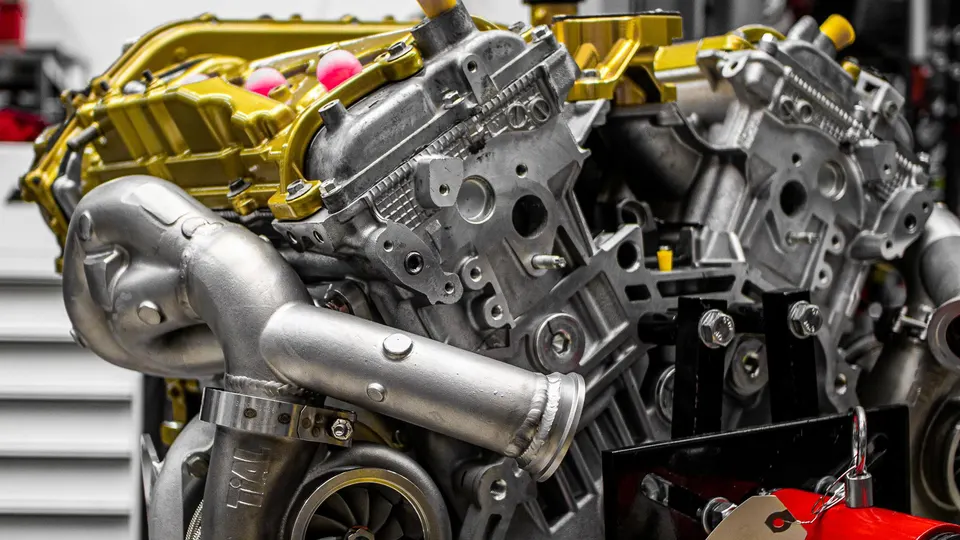 Detailed view of a high-performance built engine featuring a custom turbocharger and gold valve covers.