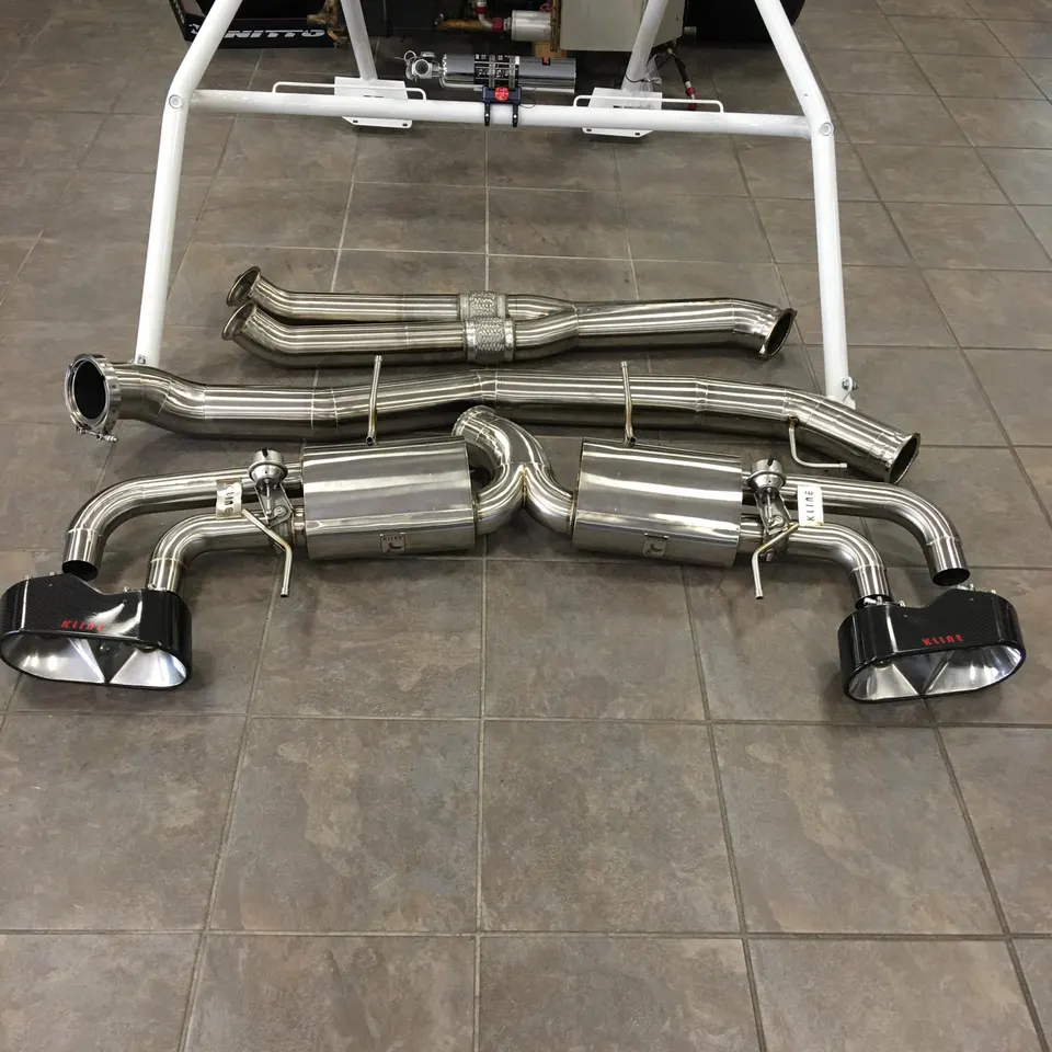 Kline Innovation titanium exhaust system with carbon fiber tips laid out on a shop floor, ready for installation.