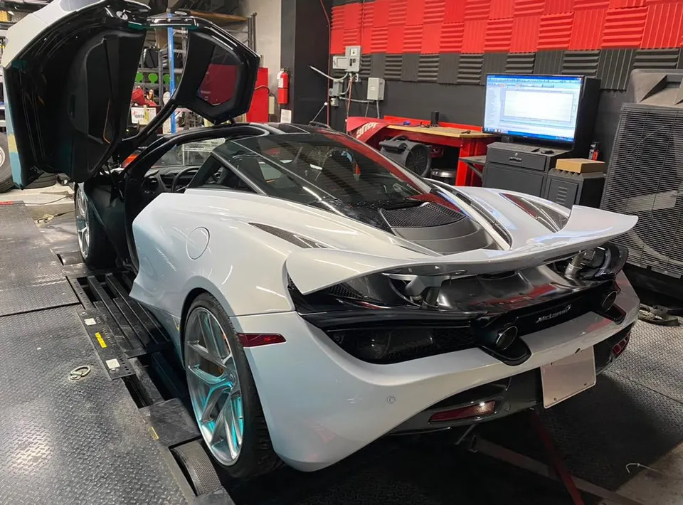 White McLaren 720S supercar strapped to a dynamometer for performance tuning at Jotech Motorsports.