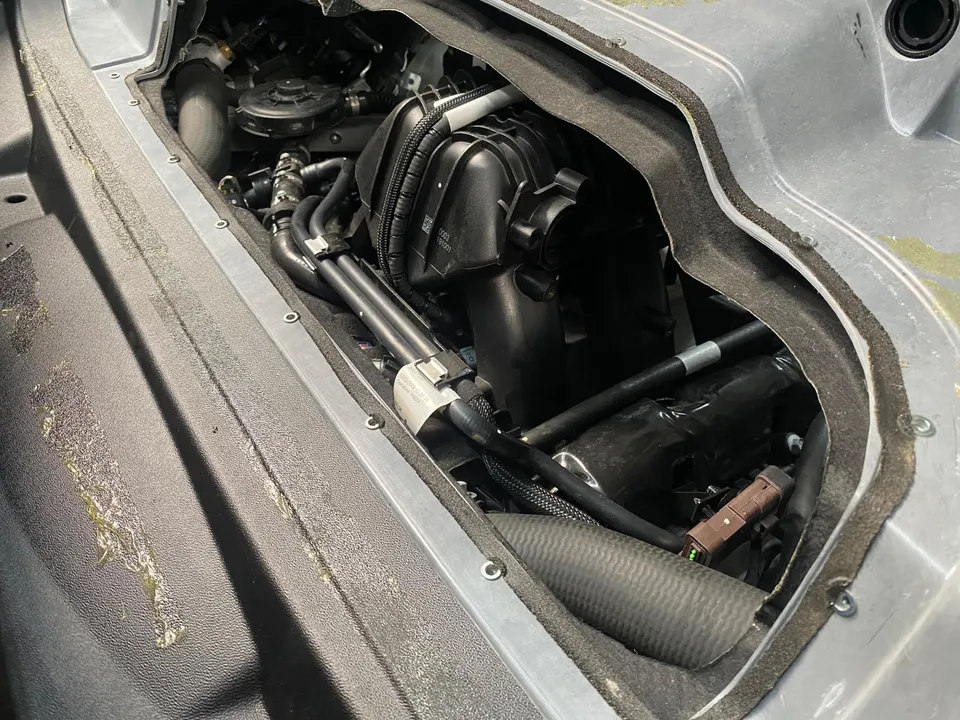 Close-up view of a car's engine bay, highlighting the air intake system and various engine components.