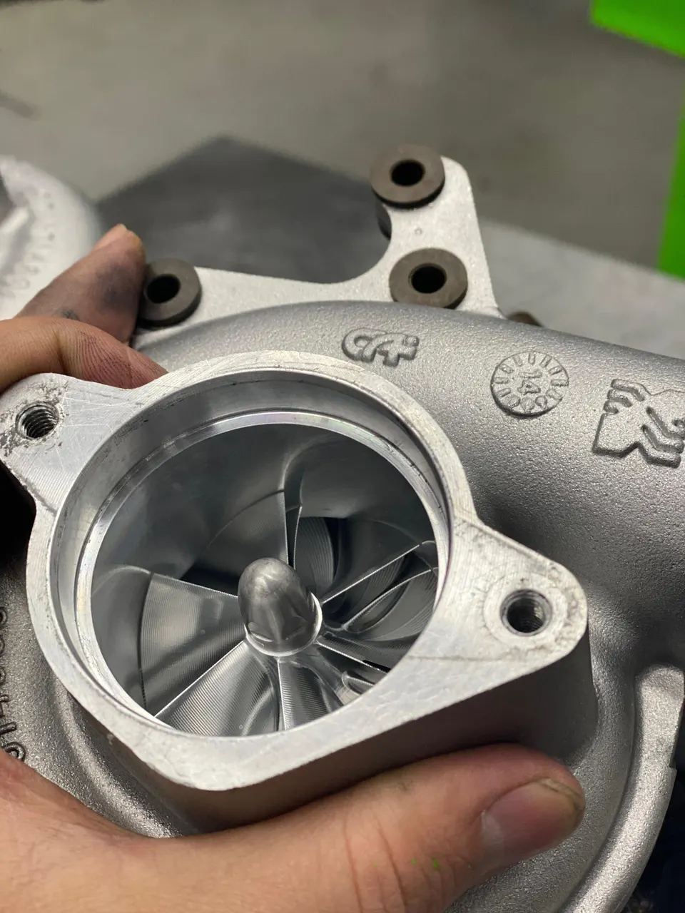 A close-up view of a new turbocharger's compressor wheel, highlighting its intricate design and metallic finish.