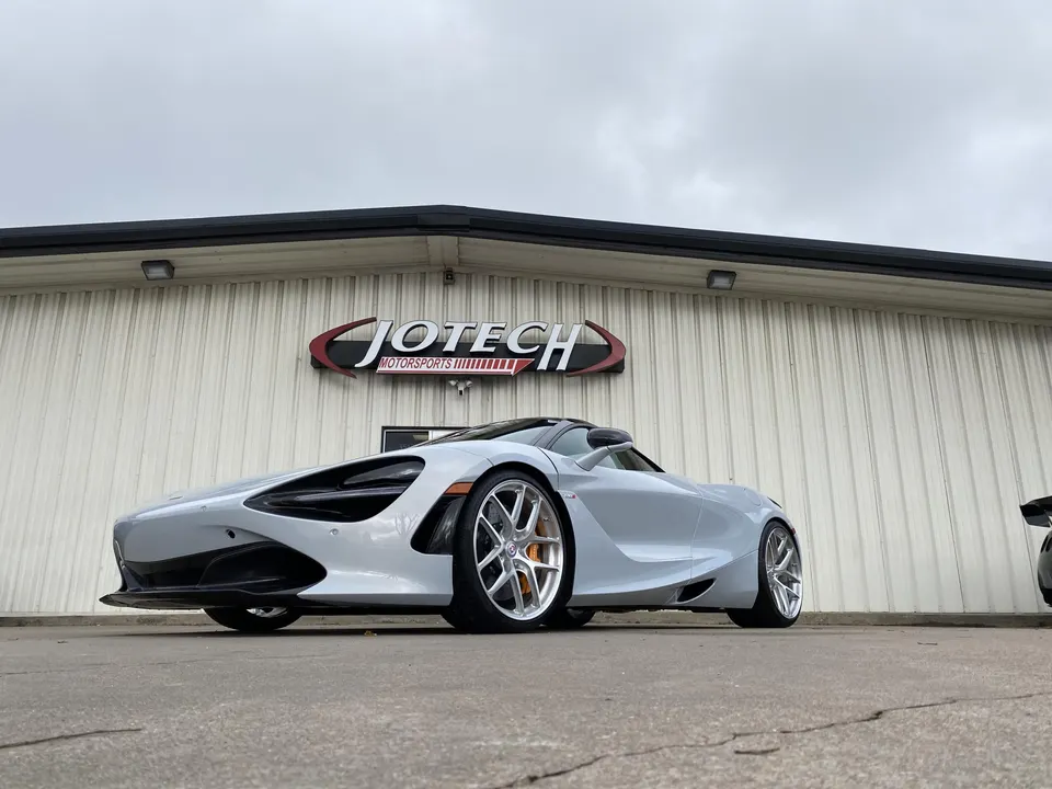 A silver McLaren 720S with aftermarket wheels parked outside Jotech Motorsports performance tuning shop.