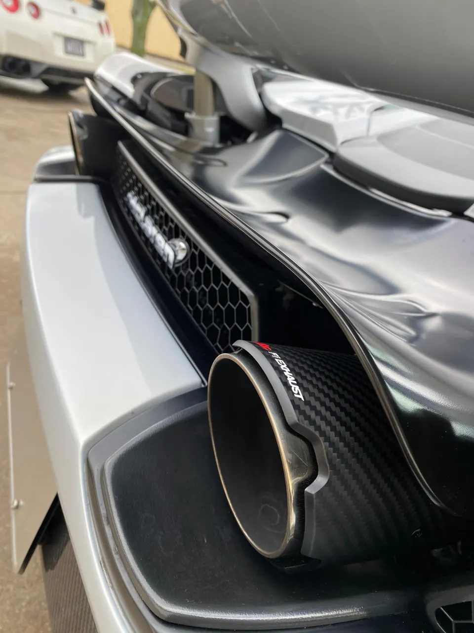 Close-up of a McLaren's rear bumper featuring a carbon fiber Fi Exhaust tip.