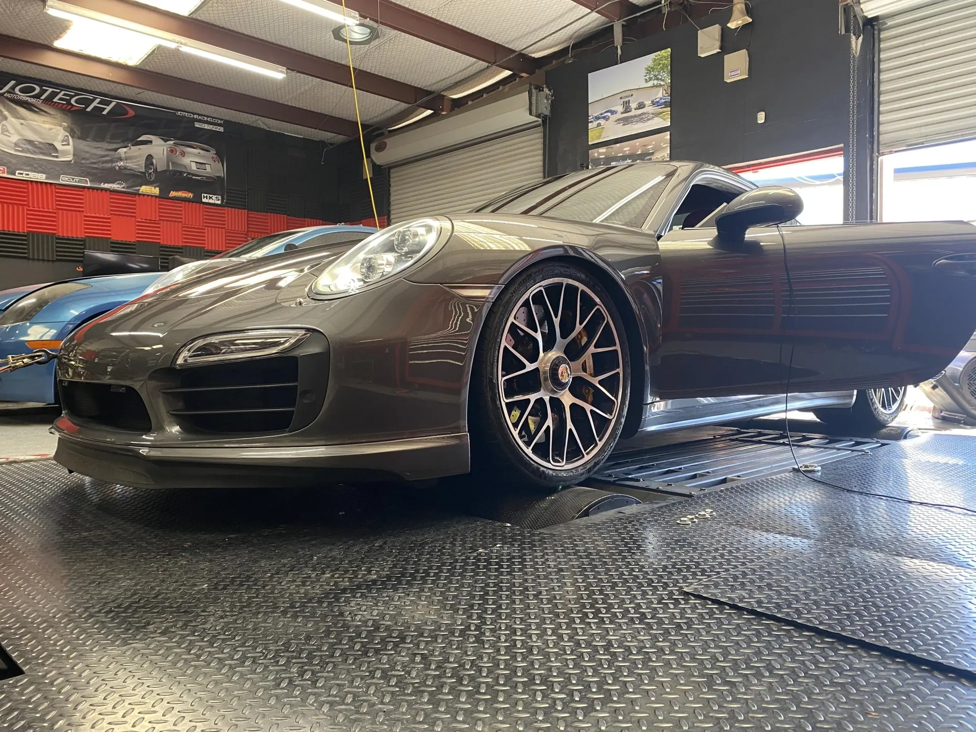 A grey Porsche 911 on a dyno at Jotech Motorsports for performance tuning.