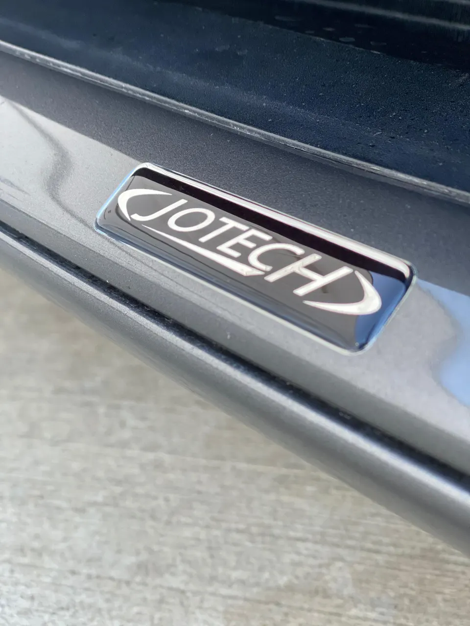A close-up of the Jotech logo emblem on a car's interior trim.