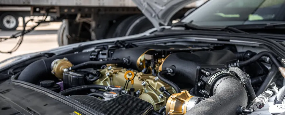 A detailed view of a Jotech Motorsports built Nissan GT-R engine bay featuring gold-painted components and performance turbo system.