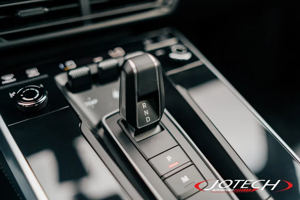 Close-up of a modern car's interior, showing the automatic gear shifter, center console, and climate controls.