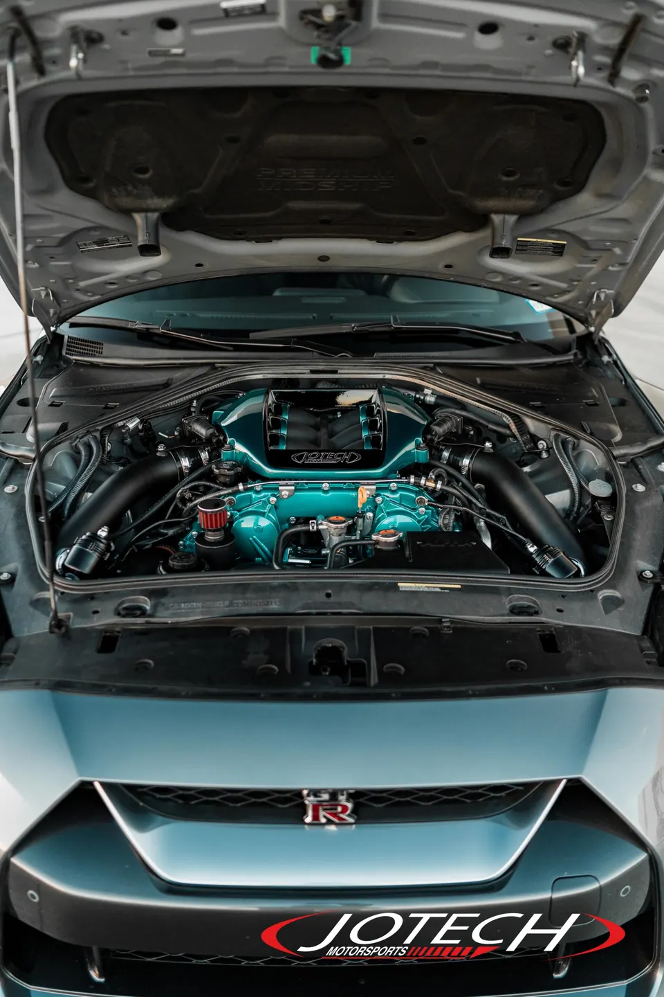 Custom teal engine bay of a Nissan GT-R R35 showcasing Jotech Motorsports performance induction system.