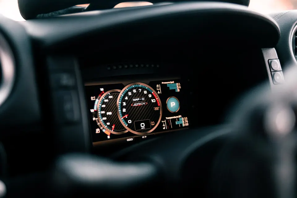 Close-up of a Jotech digital dashboard displaying performance metrics and gauges in a high-performance car.