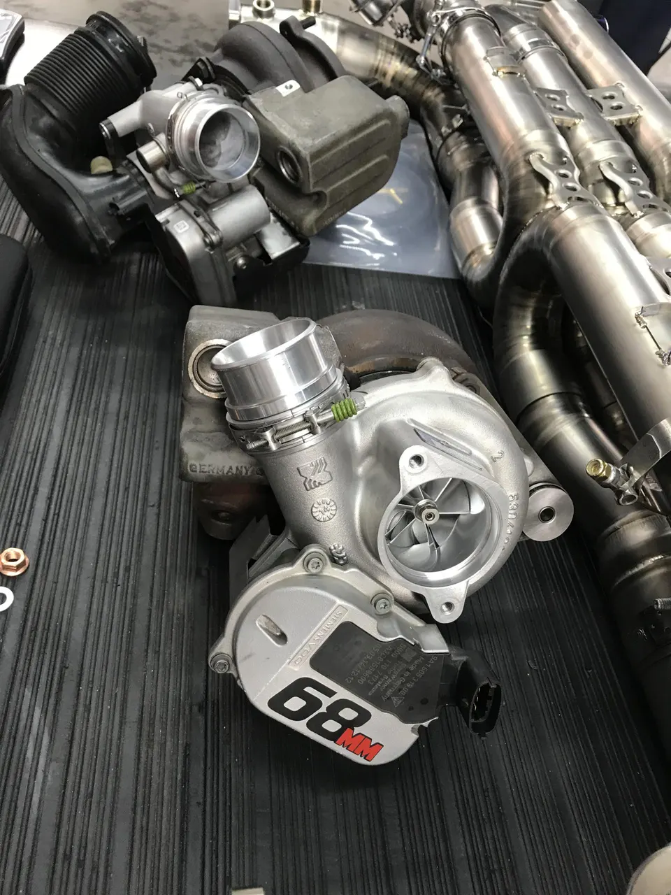 High-performance turbochargers, exhaust manifold, and throttle body for a custom engine build on a workbench.