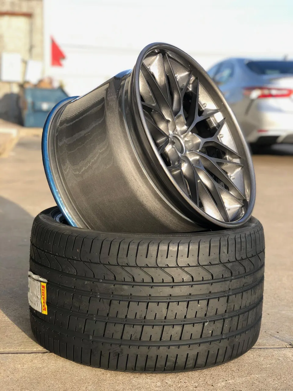 Close-up of a new aftermarket wheel with a Pirelli tire, ready for installation.