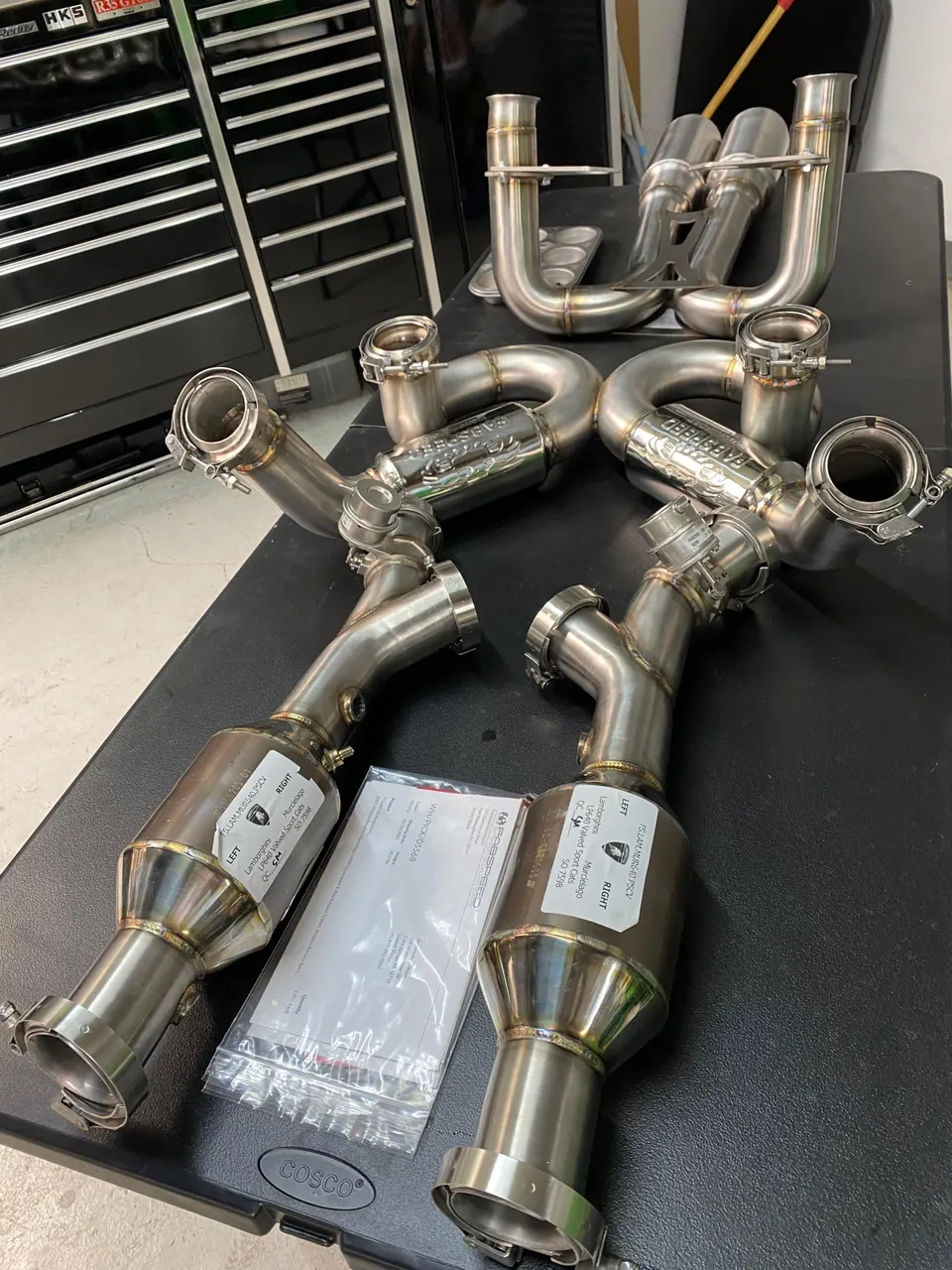 Fabspeed exhaust system with sport catalytic converters for a Lamborghini Murcielago laid out in a shop.