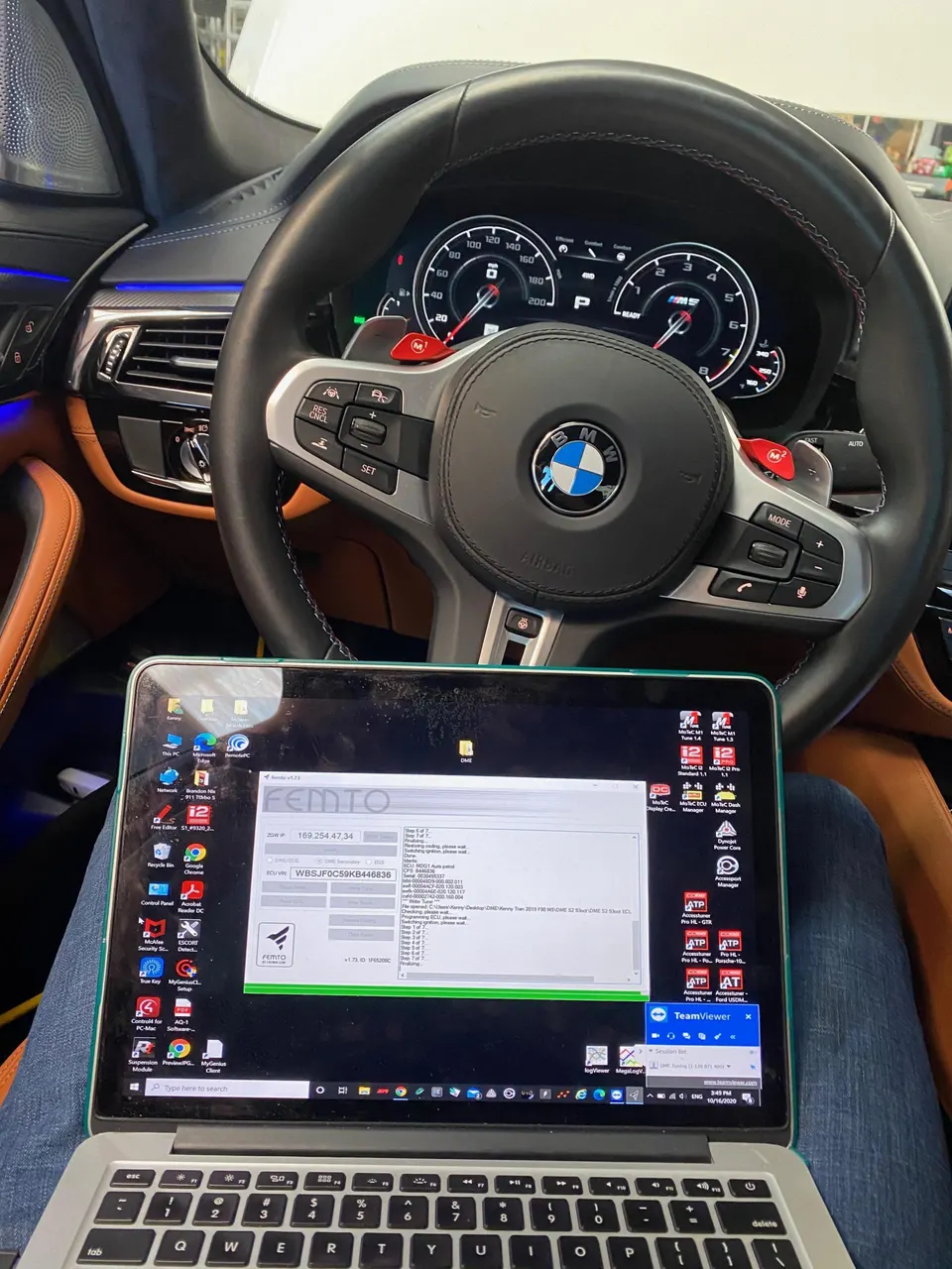 BMW M5 interior with a laptop connected for ECU tuning using Femto software.