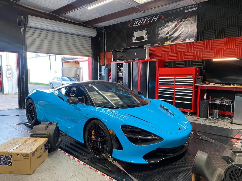 Blue McLaren 720S strapped to a dynamometer at Jotech Motorsports for performance tuning.