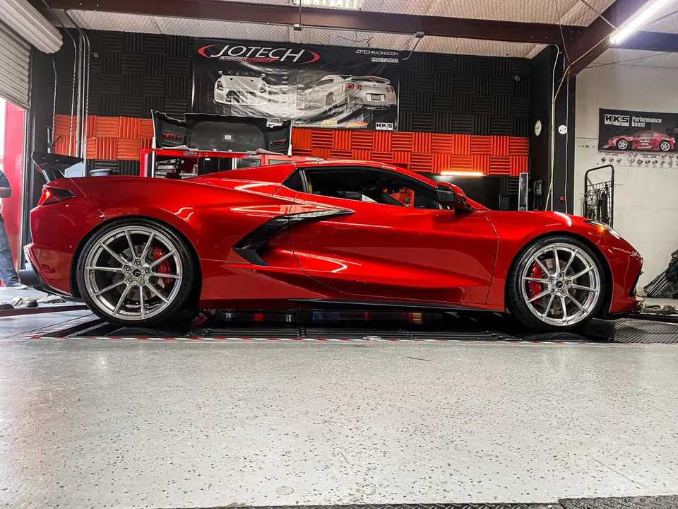 Red C8 Corvette on a dynamometer at Jotech Motorsports for performance tuning and power measurement