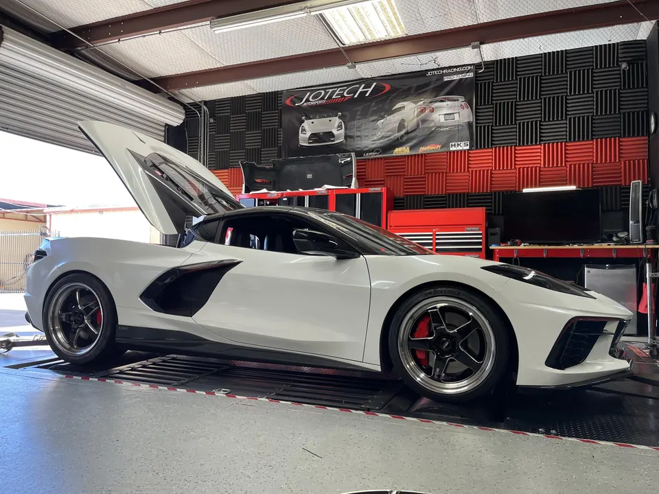 A white Corvette C8 on a dyno at Jotech Motorsports, ready for performance tuning.