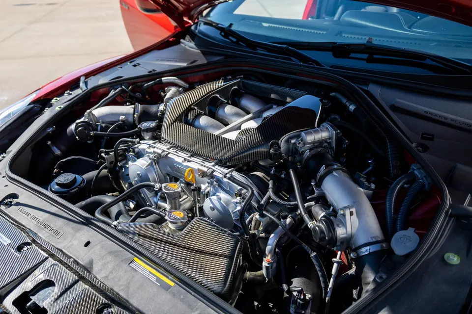 Close-up of a Nissan GT-R R35 engine bay featuring a carbon fiber induction system and intake manifold.
