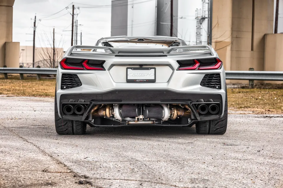 Rear view of a silver Chevrolet Corvette C8 with a visible twin-turbo setup and custom exhaust.