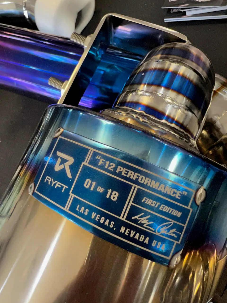 Close-up of a Ryft F12 Performance titanium exhaust tip, showing the '01 of 18 First Edition' label.