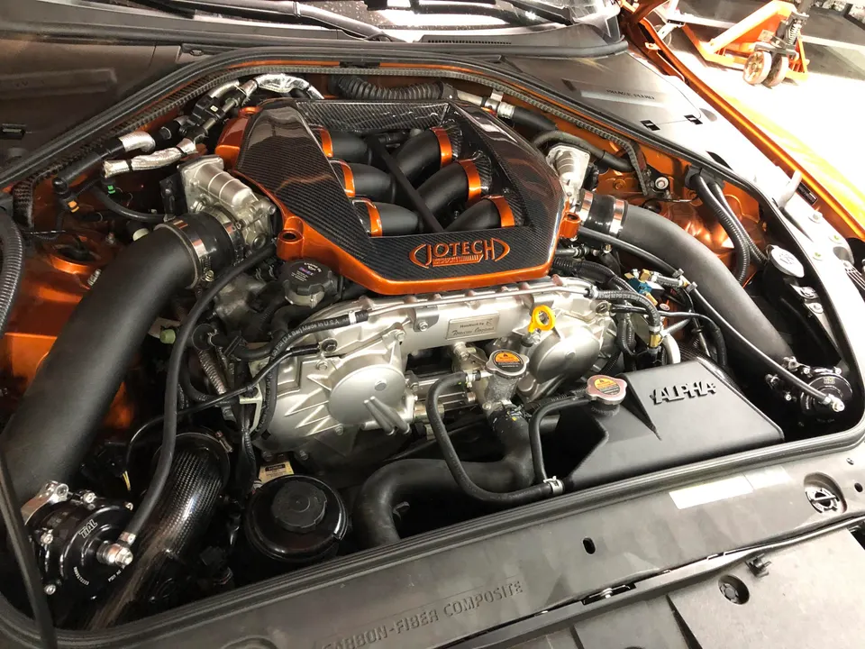 Highly modified Jotech GT-R engine bay with carbon fiber intake manifold, Alpha intercooler, and performance boost components.