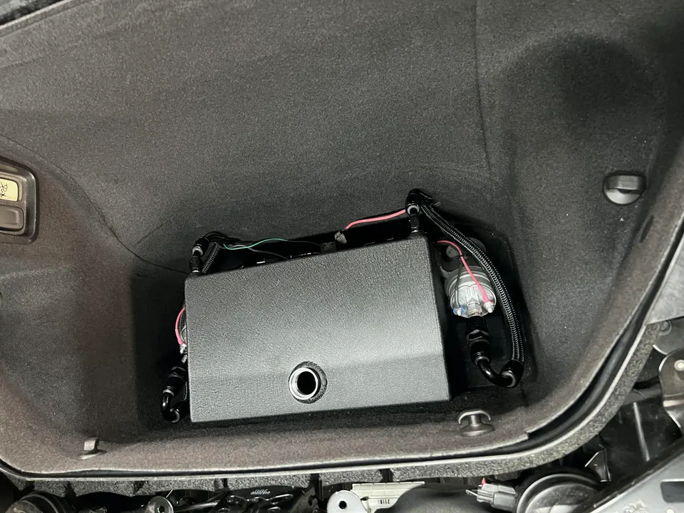 Custom fuel system installation with fuel pump and lines in a car's trunk
