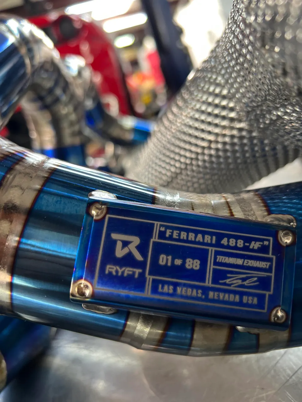 Close-up of a RYFT titanium exhaust system for a Ferrari 488-HF, showing the limited edition plaque.