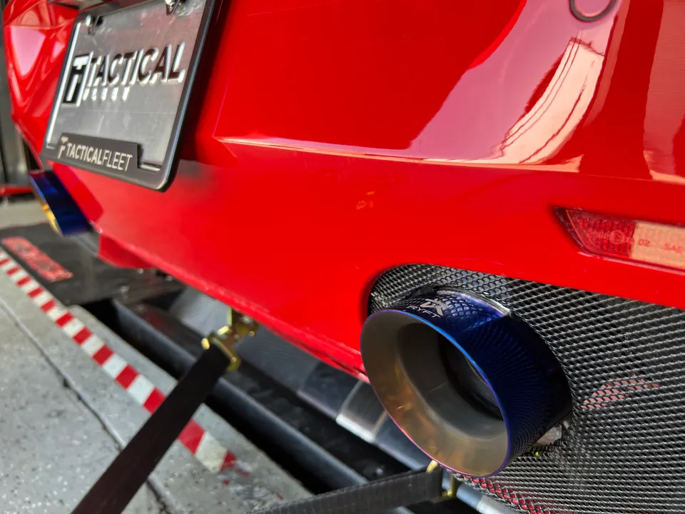 Red car on a dyno showing custom blue titanium exhaust tips and a Tactical Fleet license plate.