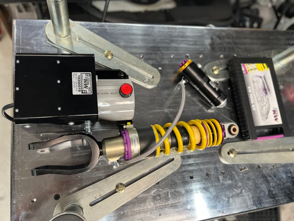 KW HLS (Hydraulic Lift System) and coilover suspension components on a workbench, ready for installation.