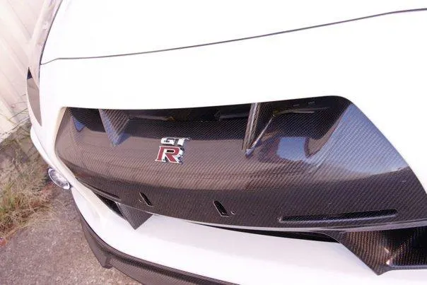 Close-up of a Nissan GT-R's carbon fiber rear diffuser with the GT-R emblem.