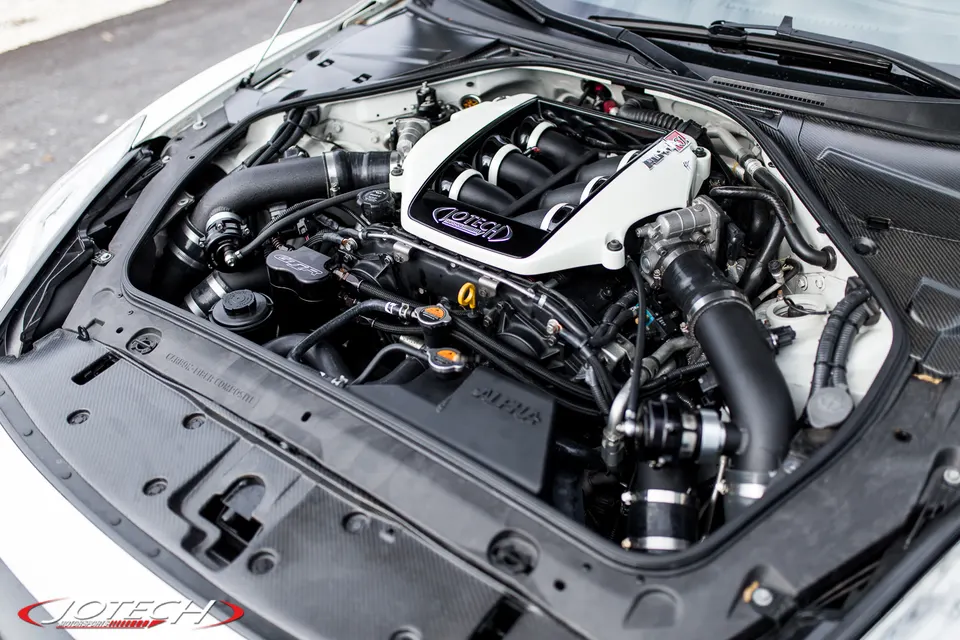 Close-up view of a Jotech-tuned Nissan GT-R engine bay featuring a custom white intake manifold and performance induction system.