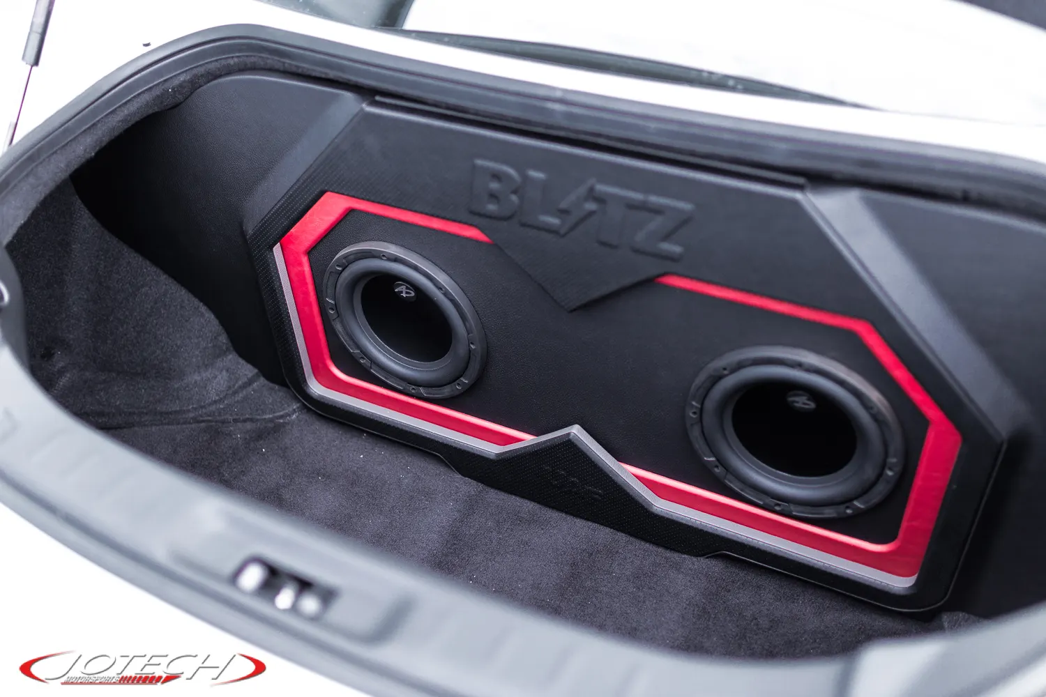 Custom Blatz subwoofer enclosure with dual subwoofers installed in the trunk of a performance car.