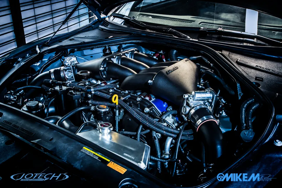 A detailed view of a Nissan GT-R R35 engine bay featuring an aftermarket intake manifold and induction system.