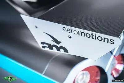 Close-up of a carbon fiber Aeromotions rear wing on a Nissan GT-R, showcasing the aerodynamic detail.