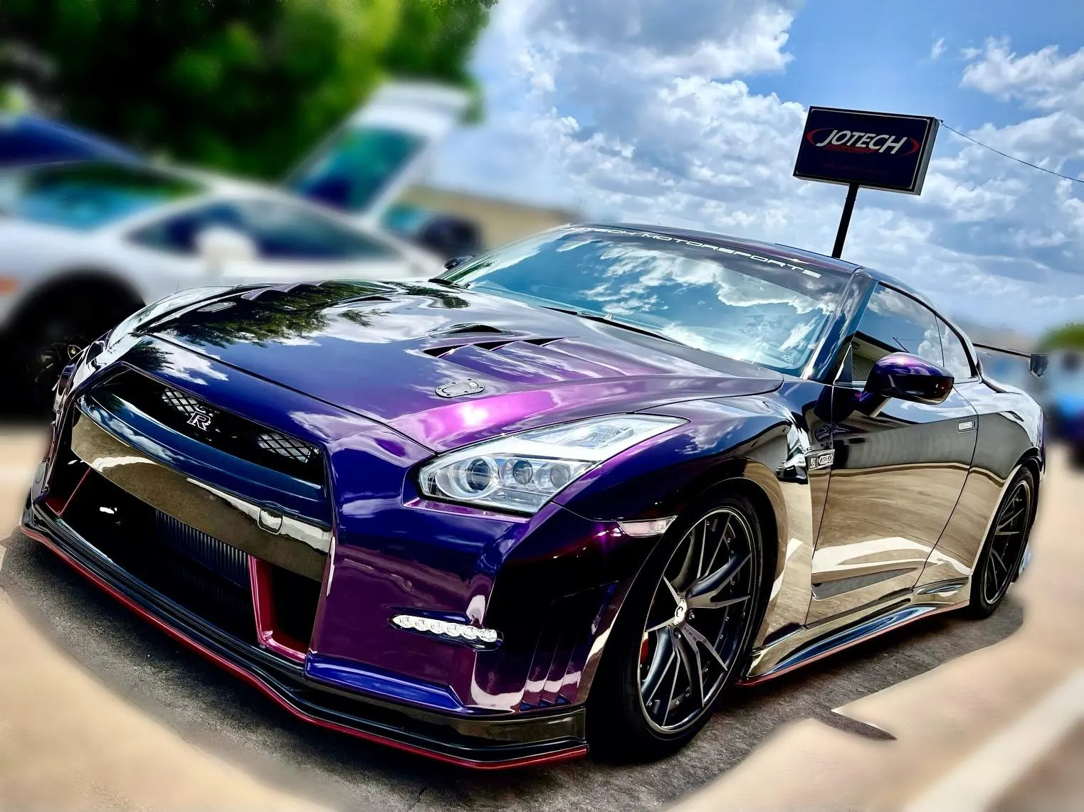 Purple Nissan GT-R with custom wrap, aftermarket wheels, and aero kit parked outside Jotech Motorsports.