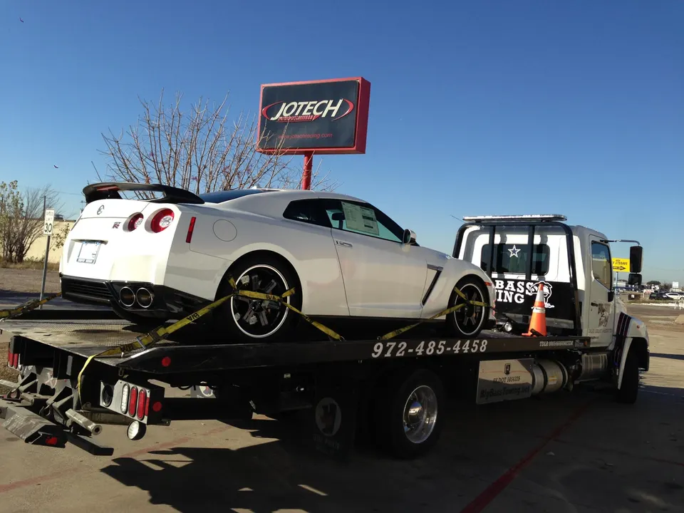 White Nissan GT-R on a tow truck outside Jotech Motorsports shop.