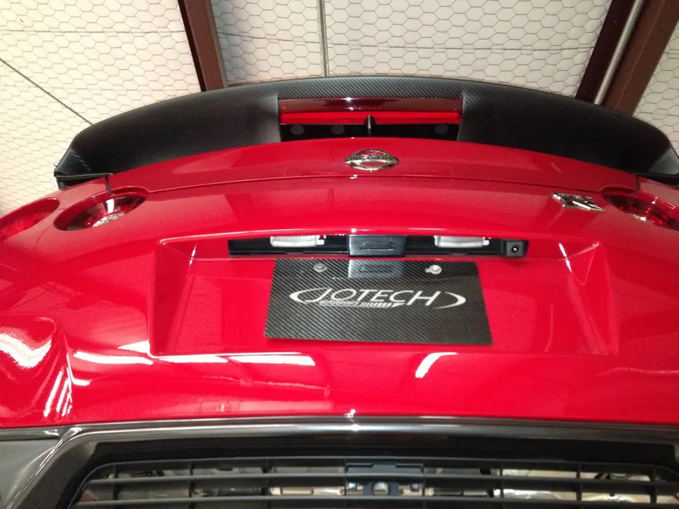 Rear view of a red Nissan GT-R with a carbon fiber spoiler and Jotech license plate frame.