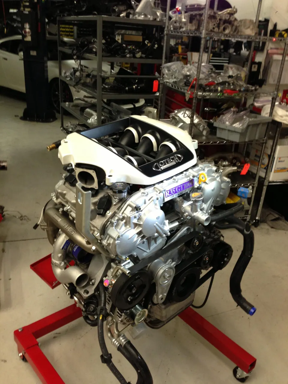 Jotech Motorsports built VR38DETT engine on a stand in a performance shop, with Jotech intake manifold and HKS turbo piping.