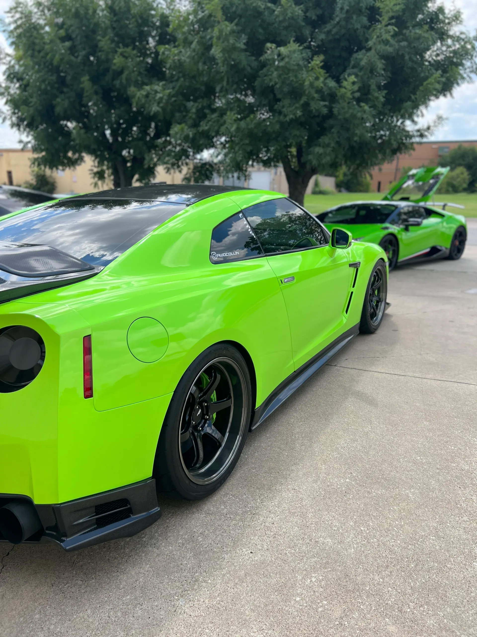 Bright green Nissan GT-R and Lamborghini Huracan parked outdoors, showcasing custom wheels and carbon fiber aero.