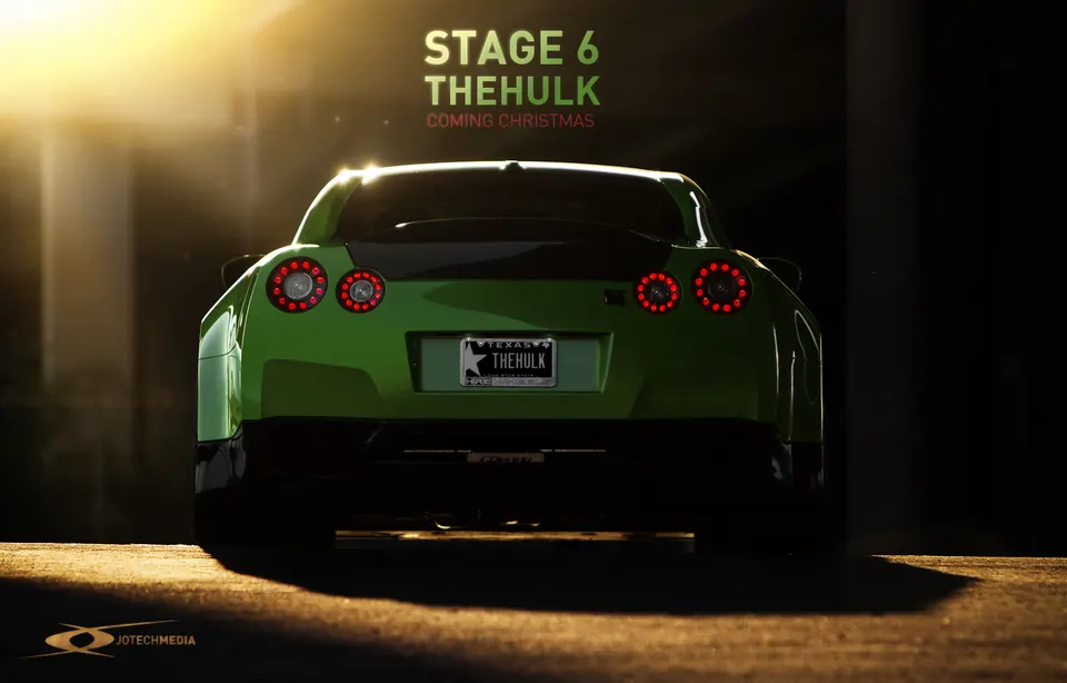 Rear view of a green Nissan GT-R, nicknamed 'The Hulk', with its taillights illuminated, in a professional photoshoot setting.