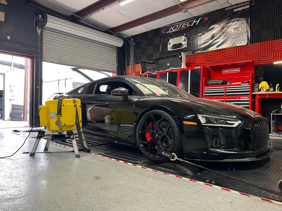 Black Audi R8 strapped to a dynamometer at Jotech Motorsports for performance tuning and horsepower measurement.