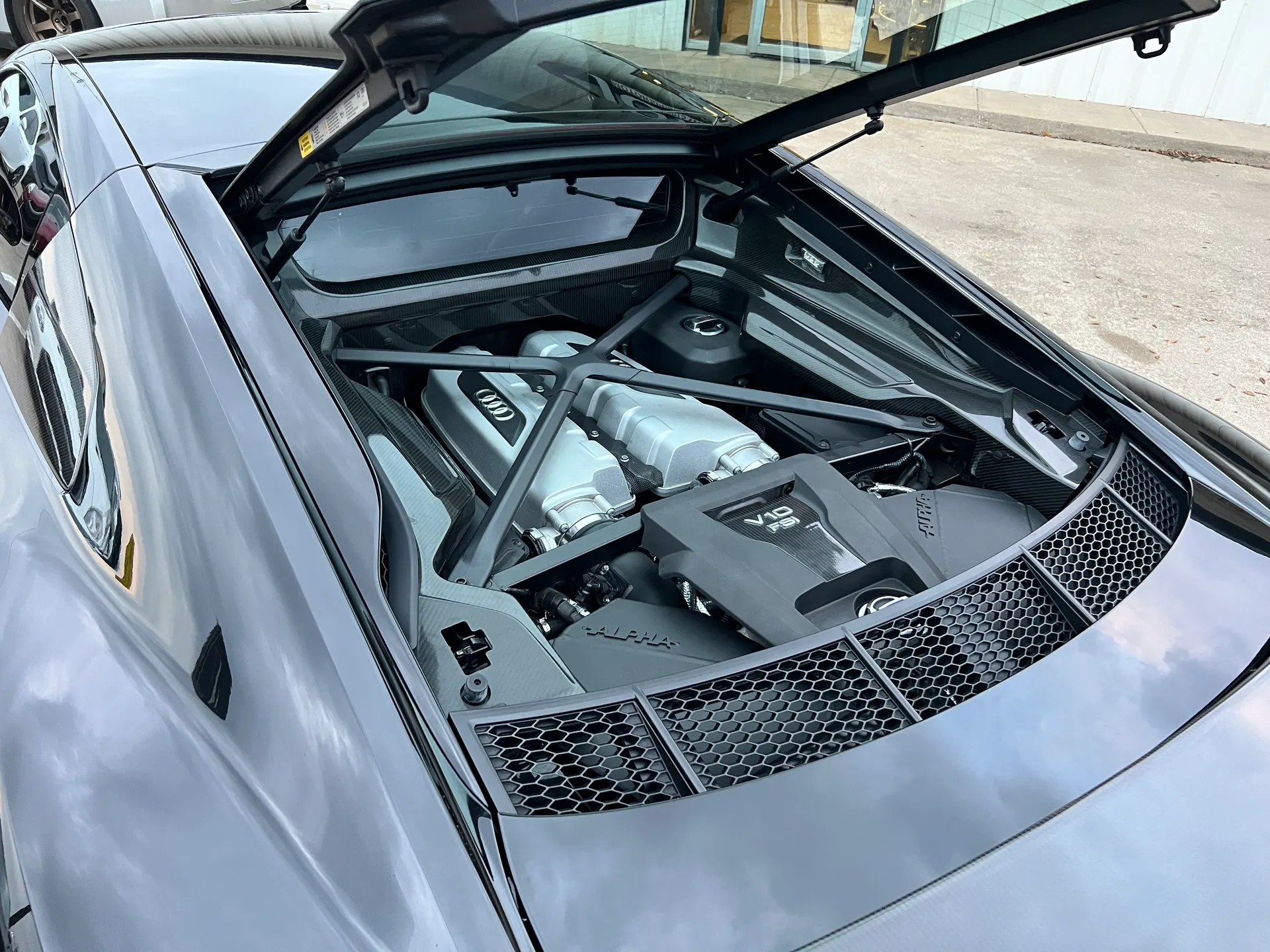Audi R8 V10 FSI engine bay with the rear hatch open, showcasing the powerful mid-mounted engine.