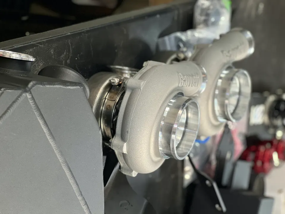Garrett turbochargers and an intercooler on a workbench in a performance tuning shop.