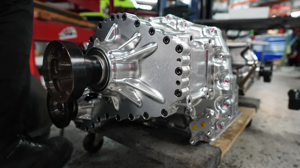 Close-up of a billet performance transmission or differential on a pallet in a tuning shop.