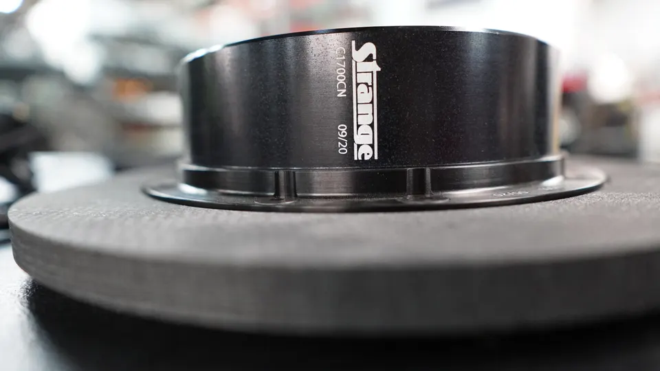 Close-up shot of a Strange Engineering performance brake rotor and hat, with 'Strange' logo visible.