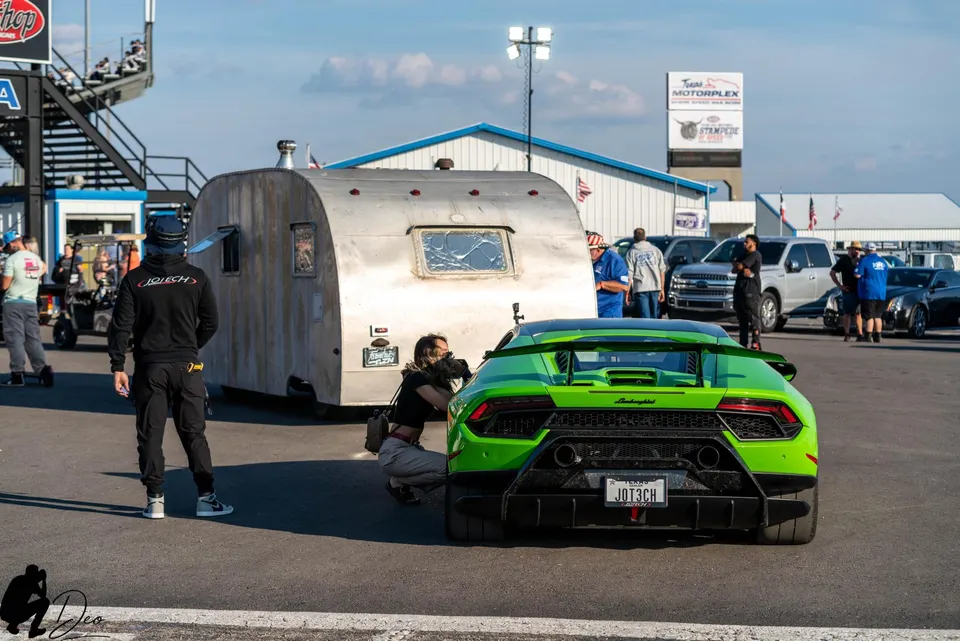 Bright green Lamborghini Huracan with a large rear wing and diffuser at Texas Motorplex, being photographed.