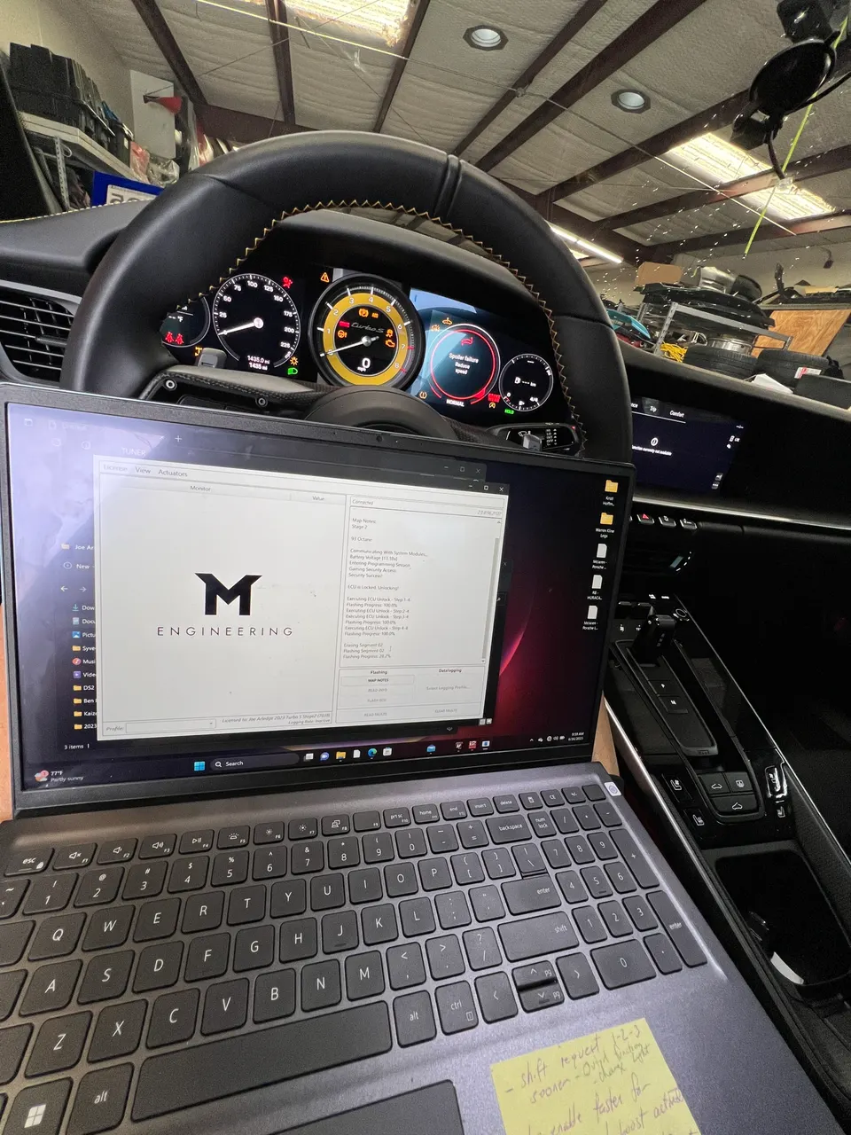 A laptop running M Engineering tuning software inside a Porsche 911, with the dashboard visible in the background.
