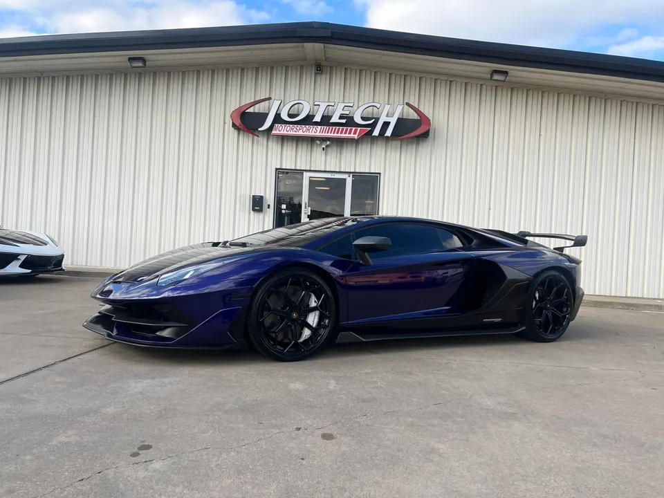 A purple Lamborghini Aventador parked outside the Jotech Motorsports facility.
