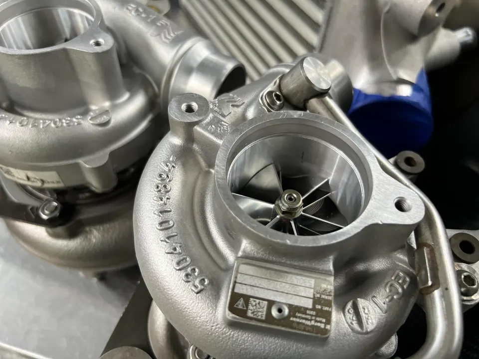Close-up of new performance turbochargers with visible compressor wheels and part numbers.