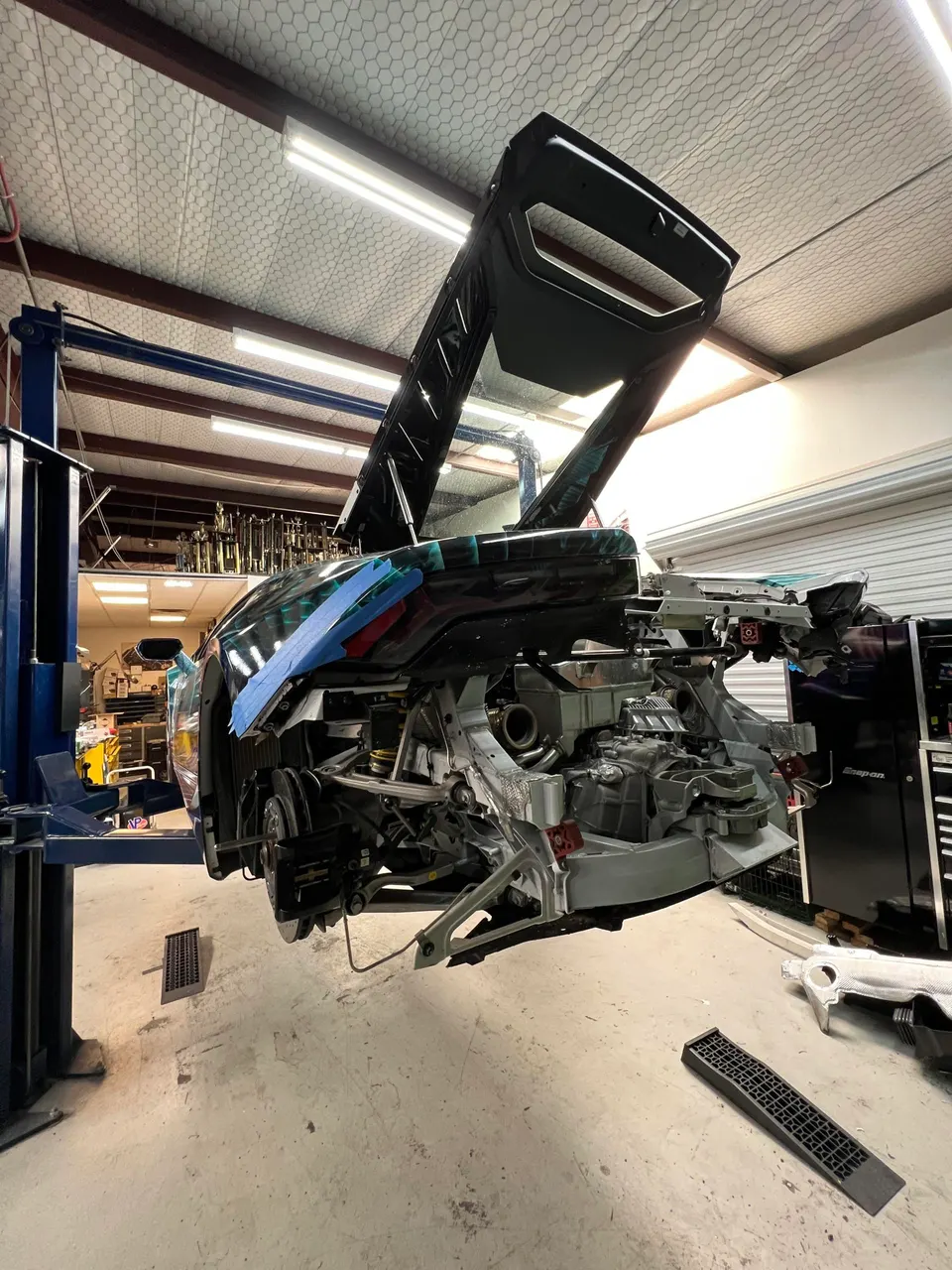 Lamborghini Huracan undergoing extensive disassembly and turbo system work on a lift in a performance shop.